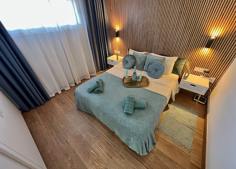 Bedroom in our Ocean View Luxury Apartment with atmospheric light and comfortable bed.