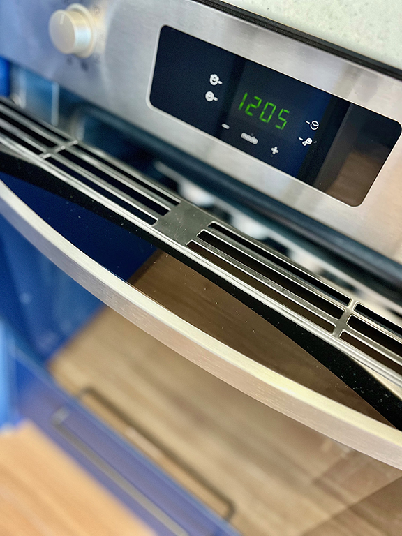 The oven in the kitchenette of the apartment, a modern built-in element perfect for preparing homemade meals.