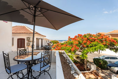 Kameralny taras apartamentu z miejscem do porannej kawy i widokiem na okoliczną zabudowę.