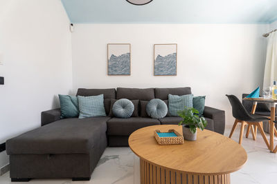 Komfortowy salon z dużą sofą i dekoracyjnymi poduszkami, idealny do relaksu.