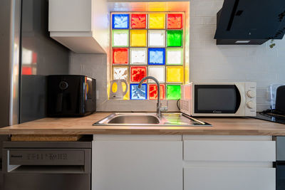 Ekskluzywna kuchnia z podświetlaną dekoracyjną ścianą i starannym wykończeniem detali.