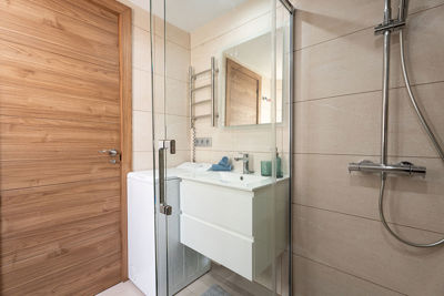 Jasna łazienka z umywalką nablatową i nowoczesną strefą prysznicową.