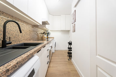 Cocina moderna con muebles de madera y electrodomésticos en un apartamento vacacional en Golf del Sur, Islas Canarias