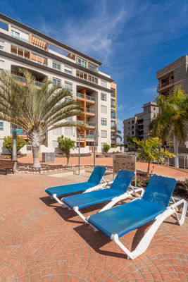 Amplio jardín con cómoda piscina rodeada de plantas tropicales en el apartamento vacacional La Vista del Mar, Islas Canarias