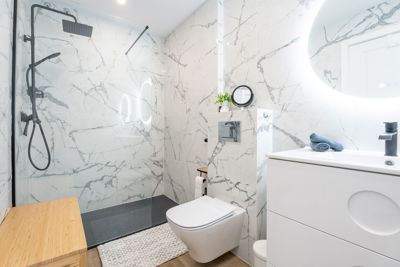 Elegante baño completo con ducha moderna y acabados de lujo en apartamento vacacional en Islas Canarias