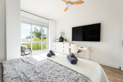 Amplia habitación con decoración moderna y televisión de pantalla plana en un apartamento de lujo en Islas Canarias.