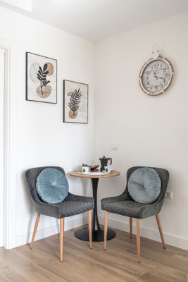 Salón luminoso con sillas modernas y decoraciones acogedoras en apartamento vacacional en Islas Canarias, España.