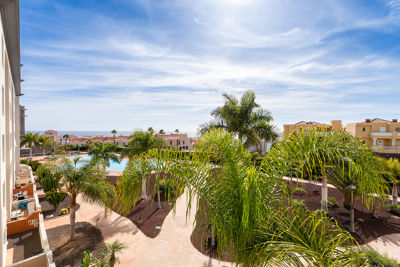 Amplia terraza con mobiliario exterior y vistas a la piscina en un apartamento de vacaciones en Islas Canarias, España