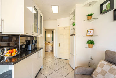 Espacioso salón con cocina integrada, decoración moderna y vistas a las Islas Canarias en el apartamento de alquiler vacacional.