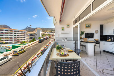 Amplia terraza con muebles de exterior y vistas al océano en un apartamento vacacional en las Islas Canarias, España.