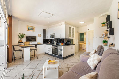 Espacioso salón con grandes ventanales y decoración moderna en apartamento de alquiler vacacional en Islas Canarias, España.