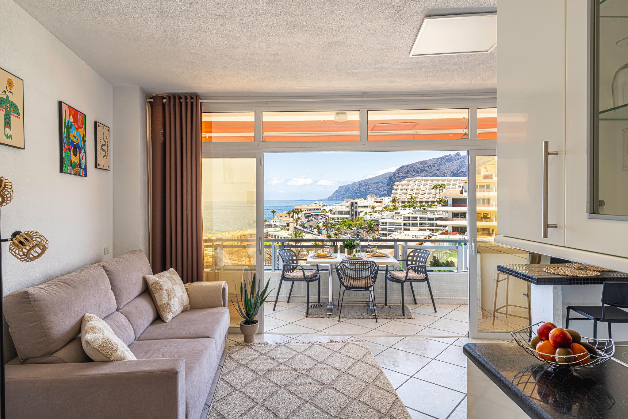 Salon spacieux avec de grandes fenêtres et décoration moderne dans un appartement de vacances aux Îles Canaries.